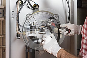 Plumber repairing a condensing boiler photo