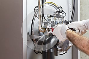 Plumber repairing a condensing boiler photo