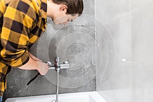 Plumber repairing faucet in shower bathroom. Close up