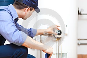 Plumber repairing an hot-water heater photo