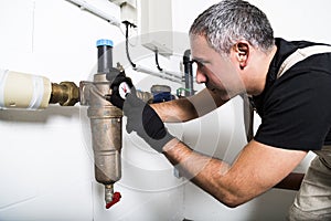 Plumber repairing metallic water pipes with manometer