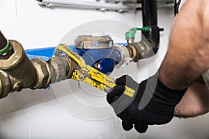 Plumber repairing metallic water pipes with manometer