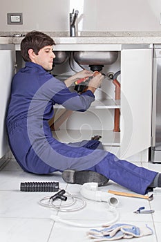 Plumber repairing the pipe of the kitchen sink