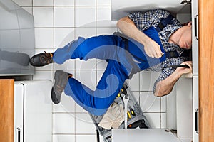 Plumber repairing sink photo