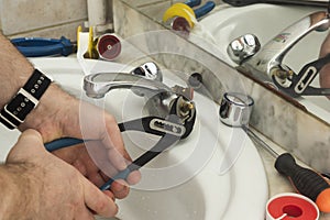 plumber repairs the faucet in the bathroom