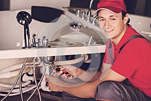 The plumber repairs the pipes. Male specialist plumber repairs.