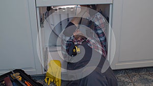 Plumber repairs a siphon leak in a kitchen sink