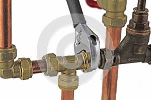 Plumber`s adjustable wrench tightening up copper pipework