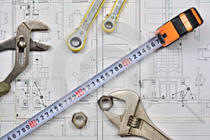 Plumber`s tools on an architectural plan of a house