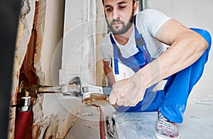 Plumber screwing plumbing fittings with a wrench