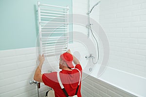 Plumber service. handyman installing heating radiator