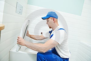 Plumber service. handyman installing toilet sink