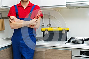 Plumber standing in domestic kitchen