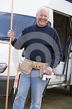 Plumber standing with van