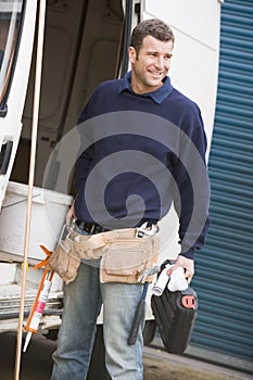 Plumber standing with van