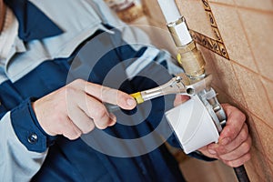 Plumber technician works with gas meter