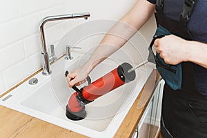 Plumber unclogging kitchen sink