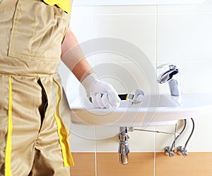 Plumber in uniform in bathroom