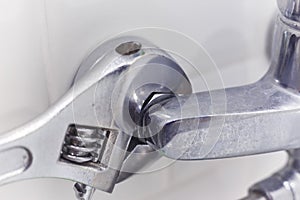 Plumber uses pipe wrench for service shower mixer tap