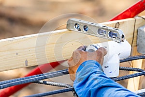 Plumber Using Level While Installing PVC Pipe At Construction Site