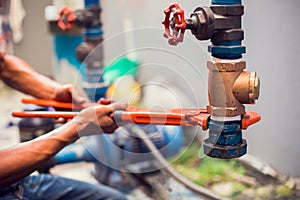 Plumber using a wrench to repair and remove the water supply pipe and valve