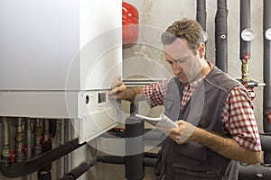 Plumber who carries out the maintenance of a condensing boiler photo