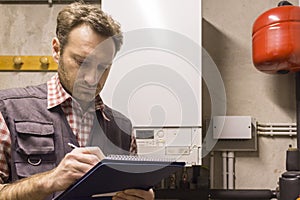 Plumber who carries out the maintenance of a condensing boiler photo