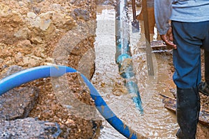 Plumber work dig repair water line connect.PVC pipe main plumbing on road and backhoe