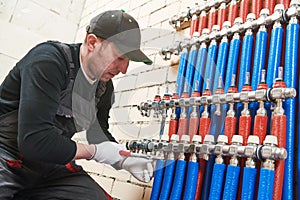 Plumber work. Installing collector for warm water underfloor heating system