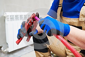 Plumber at work. Installing water heating radiator