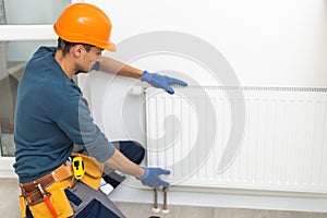 plumber at work. Installing water heating radiator