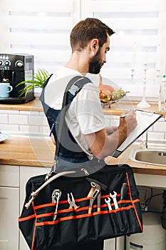 Plumber work in uniform holding bag with equipment