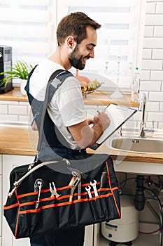 Plumber work in uniform holding bag with equipment