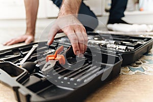 Plumber work in uniform indoors with case with equipment