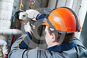 Plumber worker works with heating water meter