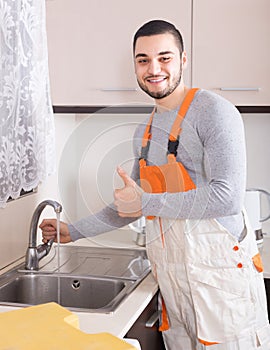 Plumber working at home of client