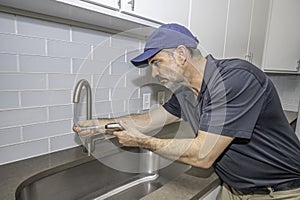 Plumber working on a kitchen faucet