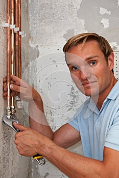 Plumber Working On Pipes At Construction Site