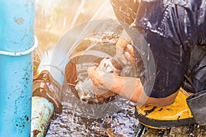 Plumber working repair the broken pipe and replace in hole with water Motion at roadside