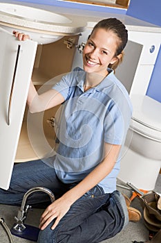 Plumber working on sink smiling