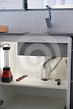 Plumber working tools fixing and repairing a kitchen faucet tap leaking
