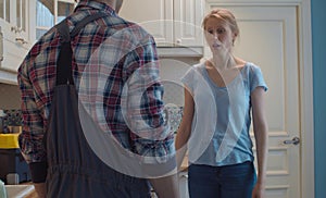 Plumber and young woman in the kitchen