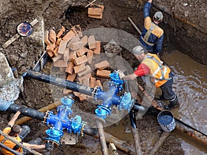 Plumbers fix a leaky underground pipeline