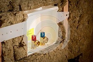 Plumbing cowling in a rough cut new home construction surrounded by insulation