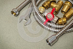 Plumbing materials faucet, tool, fittings and hose on dark green background are used for replacement in the shower