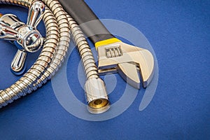 Plumbing materials faucet, tool and hose on blue background are used for replacement in the shower