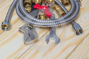 Plumbing materials, faucet, tools, fittings and hose on wooden boards are used to replace or repair