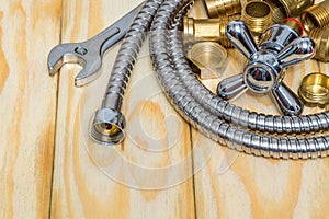Plumbing materials, faucet, tools, fittings and hose on wooden boards are used to replace or repair