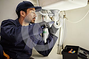 Plumbing, pipes and maintenance with man in kitchen for repair, industrial and inspection. Handyman, tools and safety