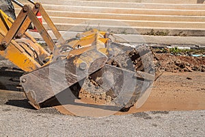 Plumbing Repair Man and excavator scoop digging, Repair of pipe